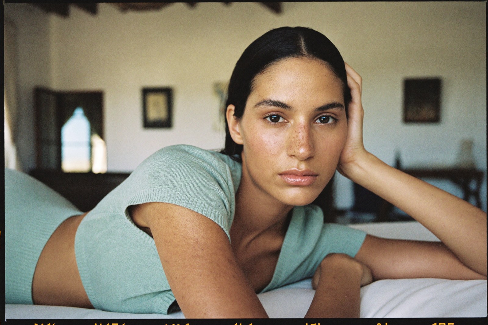 Close portrait in a mint knit, soft villa daylight, direct gaze